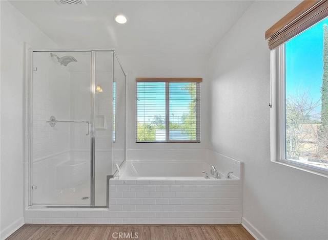 bathroom with hardwood / wood-style floors and separate shower and tub