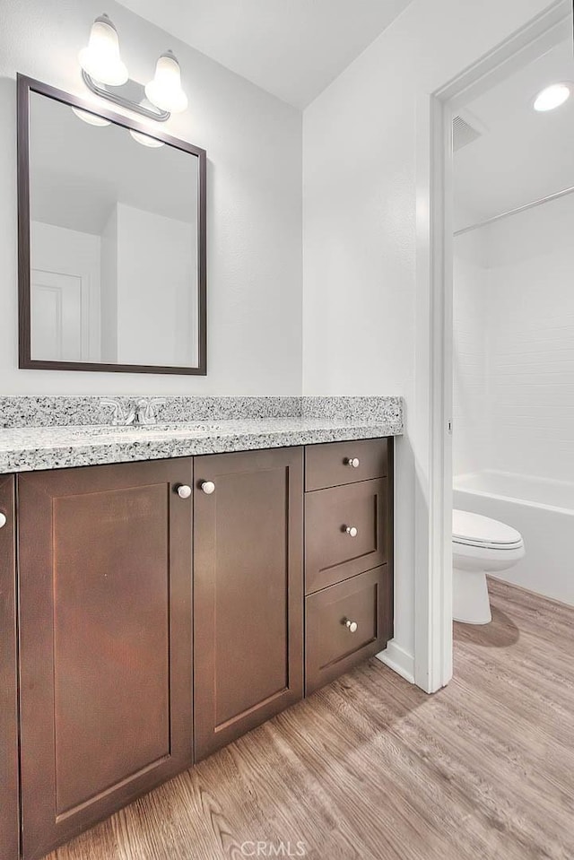 full bathroom with vanity, wood-type flooring, bathtub / shower combination, and toilet