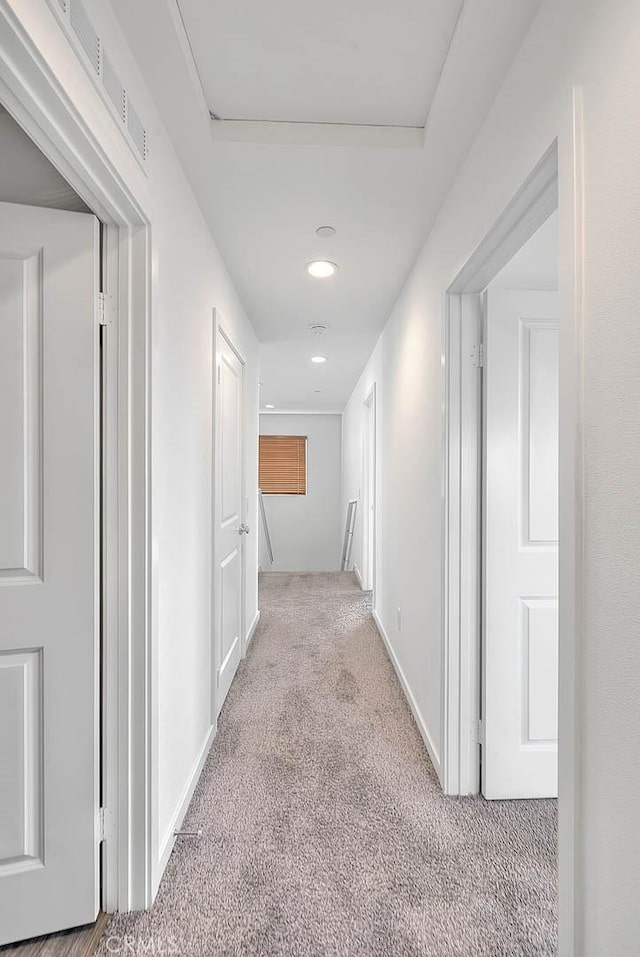 hallway with light colored carpet