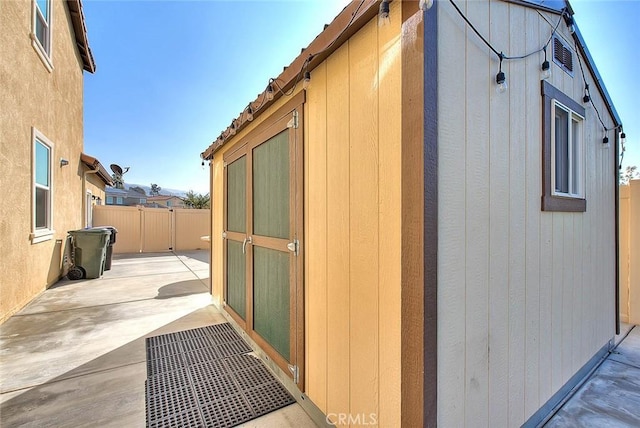 view of property exterior featuring a shed and a patio