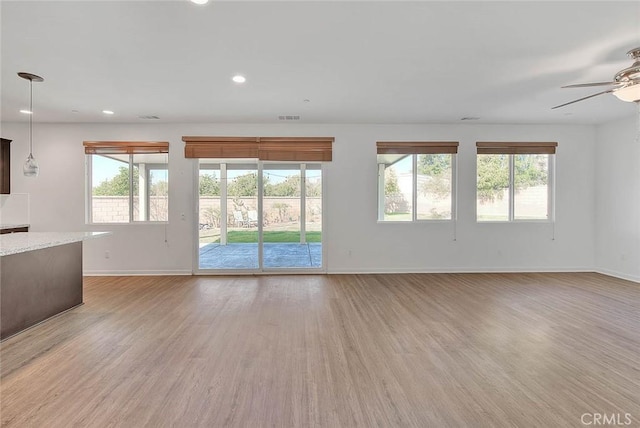 unfurnished living room featuring ceiling fan and light wood-type flooring