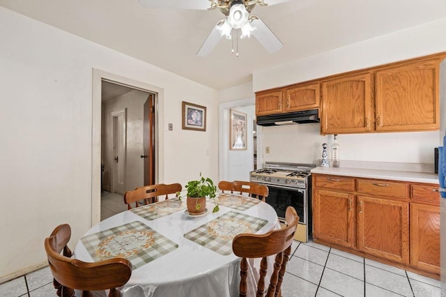 kitchen with stainless steel range with gas stovetop, ceiling fan, and light tile patterned floors