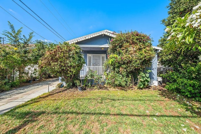 view of property hidden behind natural elements with a front yard