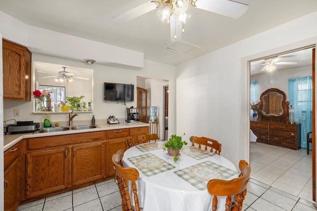 kitchen with sink, light tile patterned floors, and ceiling fan