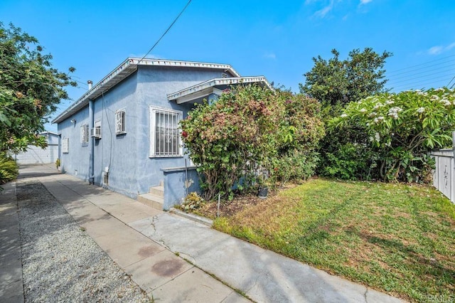 view of property exterior featuring an outbuilding, a garage, and a lawn