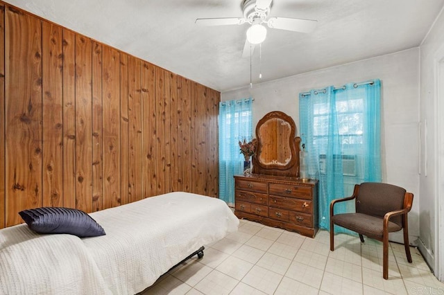 bedroom featuring ceiling fan and wood walls