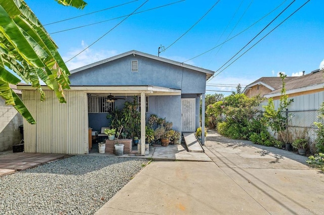 rear view of property with a patio area and ceiling fan