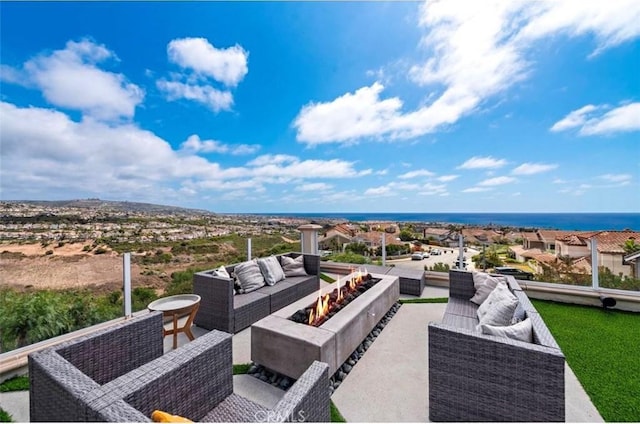 view of patio featuring an outdoor living space with a fire pit and a water view