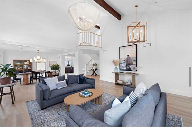 living room with an inviting chandelier, beam ceiling, and hardwood / wood-style floors