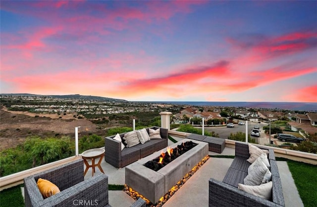 patio terrace at dusk featuring an outdoor living space with a fire pit