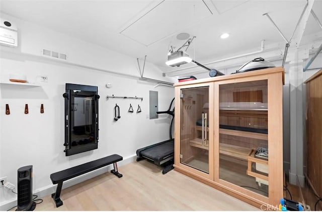 workout area with wood-type flooring and electric panel