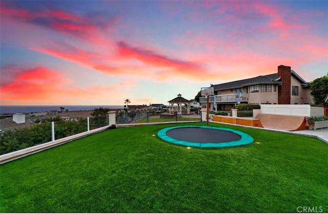 yard at dusk with a trampoline