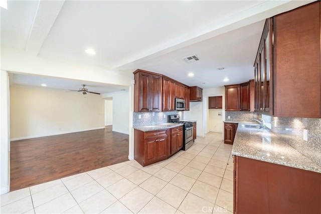 kitchen featuring light stone counters, stainless steel appliances, and light tile patterned floors