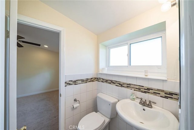 bathroom featuring vaulted ceiling, sink, tile walls, toilet, and tile patterned floors