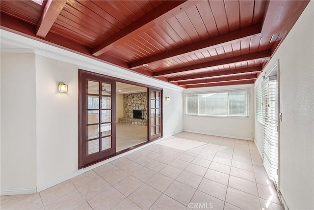 unfurnished sunroom featuring french doors, a fireplace, beam ceiling, and wooden ceiling