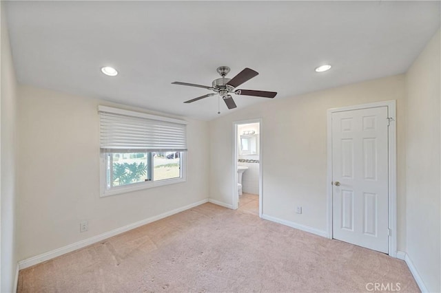 unfurnished bedroom with vaulted ceiling, ceiling fan, light carpet, and ensuite bath