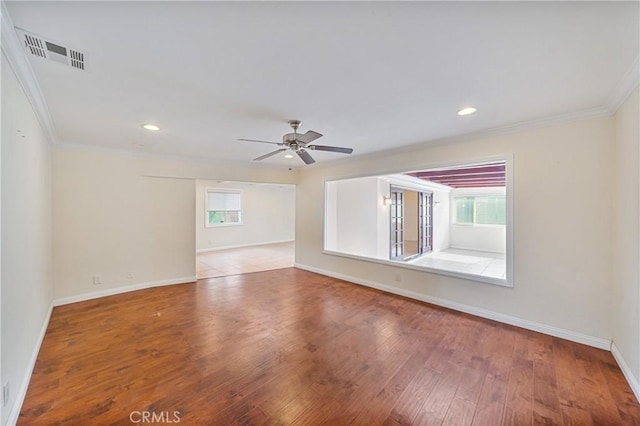 empty room featuring ceiling fan, plenty of natural light, hardwood / wood-style floors, and ornamental molding