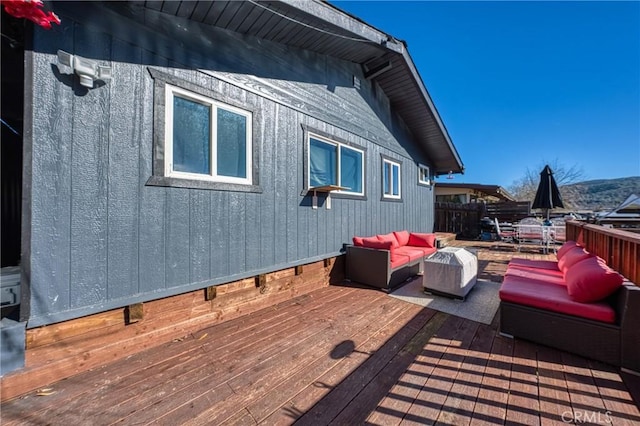 wooden terrace with an outdoor living space and a mountain view