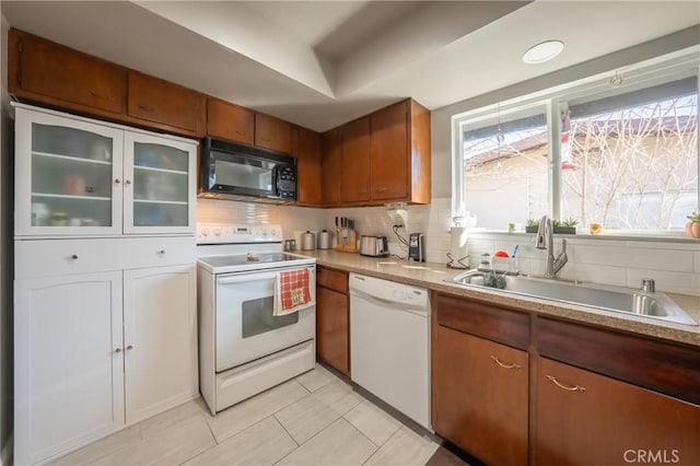 kitchen featuring tasteful backsplash, white appliances, sink, and light tile patterned floors