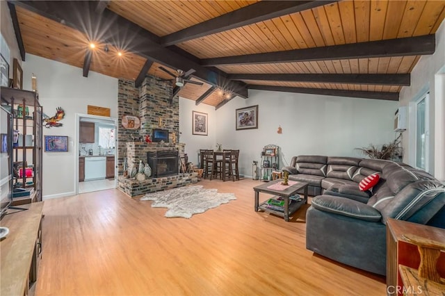 living room featuring lofted ceiling with beams, wooden ceiling, a fireplace, and light hardwood / wood-style flooring