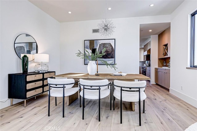 dining area featuring an inviting chandelier and light hardwood / wood-style flooring