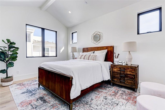 bedroom featuring lofted ceiling with beams and light wood-type flooring