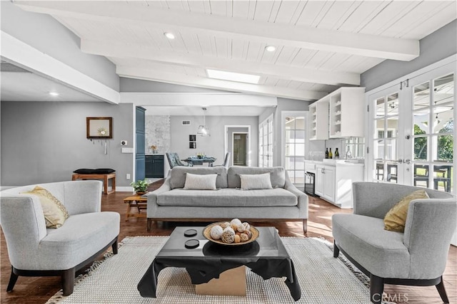 living room with lofted ceiling with skylight, french doors, and light wood-type flooring