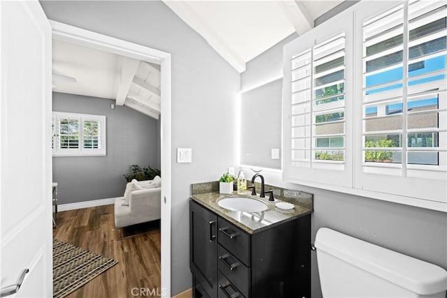 bathroom with vanity, hardwood / wood-style floors, lofted ceiling with beams, and toilet