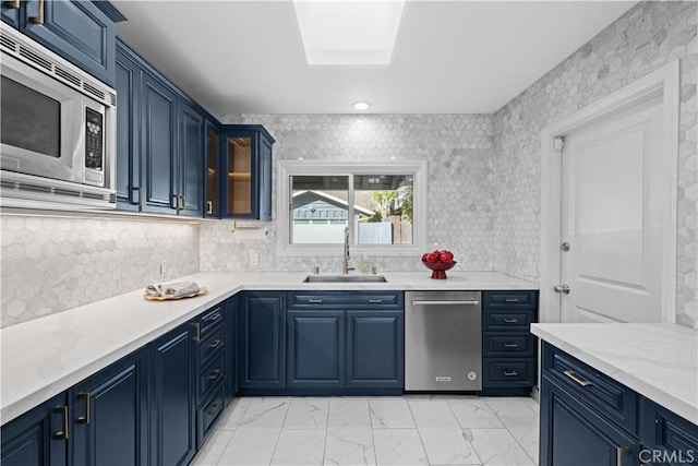 kitchen with blue cabinetry, appliances with stainless steel finishes, and sink