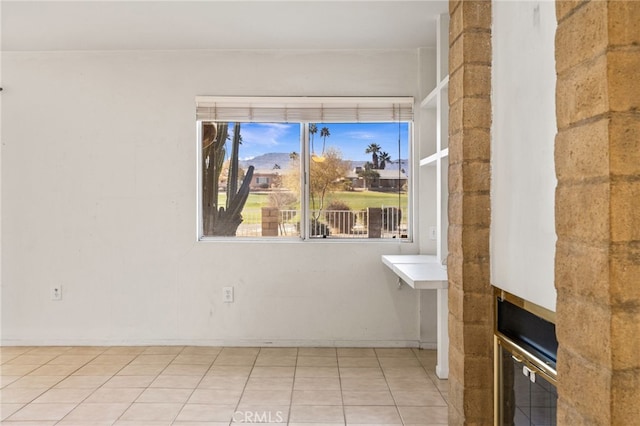 unfurnished room with light tile patterned flooring and a fireplace