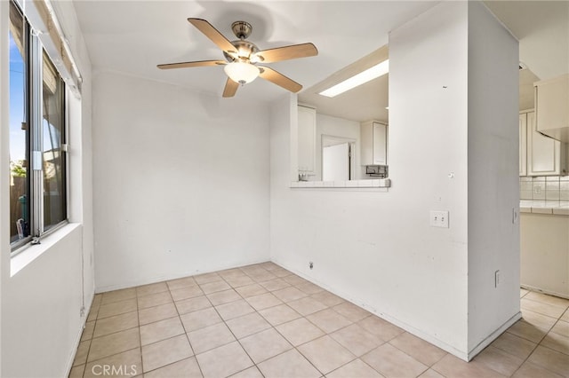 tiled spare room with ceiling fan