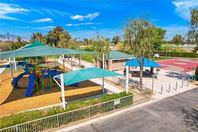 view of home's community featuring fence, community basketball court, and playground community