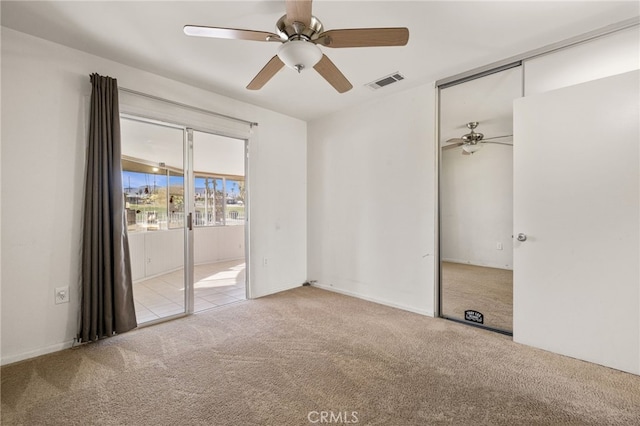 spare room featuring light colored carpet and ceiling fan