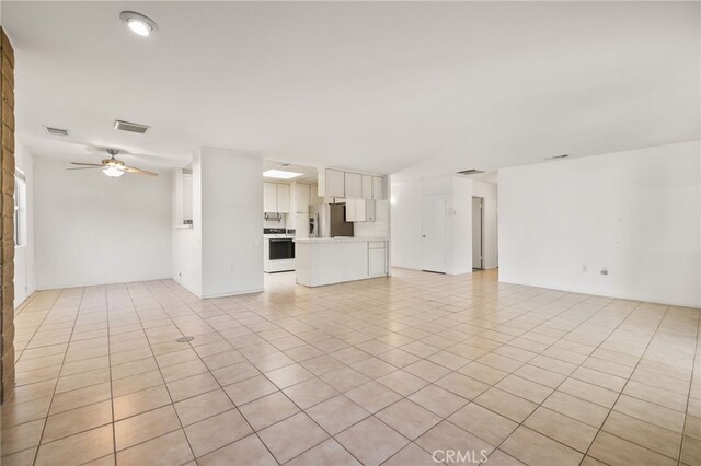 unfurnished living room featuring light tile patterned floors and ceiling fan