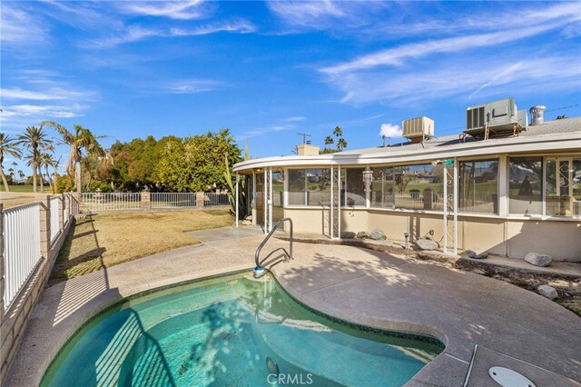 view of swimming pool featuring a patio, a fenced backyard, a fenced in pool, and central AC unit
