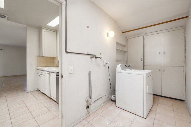 clothes washing area with light tile patterned floors, visible vents, cabinet space, and washer / dryer