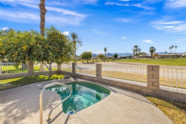 view of swimming pool with fence and an in ground hot tub