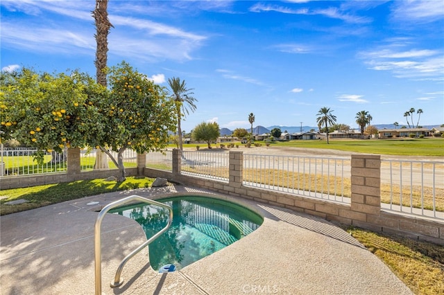 view of swimming pool with an in ground hot tub, fence, and a residential view