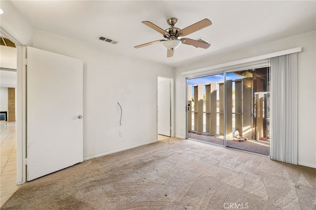 carpeted spare room featuring baseboards, visible vents, and a ceiling fan