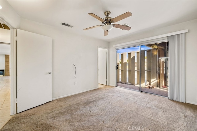 empty room featuring visible vents, a ceiling fan, and carpet floors