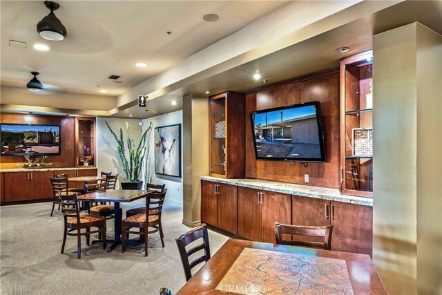 bar with light stone counters and light colored carpet