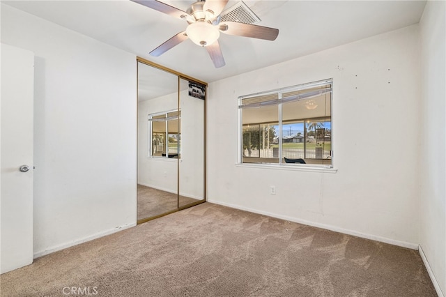 unfurnished bedroom with a closet, carpet, a ceiling fan, and baseboards