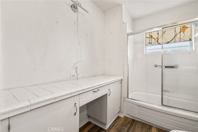 full bath featuring enclosed tub / shower combo and wood finished floors