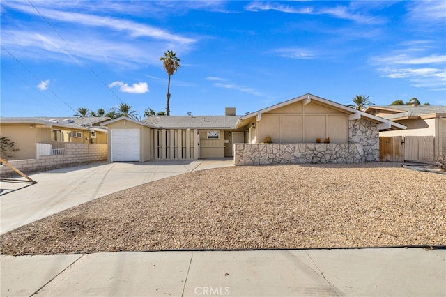 ranch-style house with driveway, an attached garage, and fence