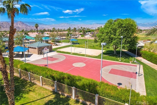 view of basketball court featuring a yard, community basketball court, fence, and a mountain view