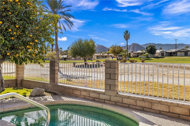 view of pool with a swimming pool, fence, and a mountain view