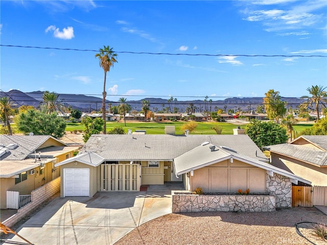 ranch-style house with fence, an attached garage, concrete driveway, and a residential view