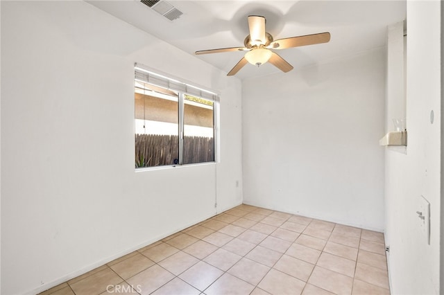 empty room with a ceiling fan, visible vents, and light tile patterned floors
