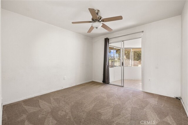 spare room featuring carpet floors, ceiling fan, and baseboards