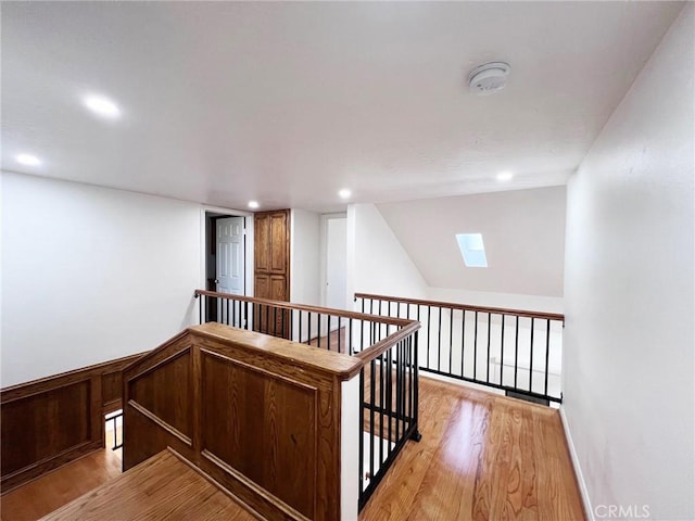 hall with a skylight and light wood-type flooring